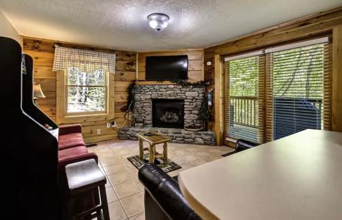 a living room with a table and a fireplace at Best Value Cabin Hot Tub Arcade Close to Strip in Pigeon Forge