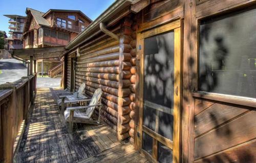 a porch of a log cabin with two chairs on it at Best Value Cabin Hot Tub Arcade Close to Strip in Pigeon Forge