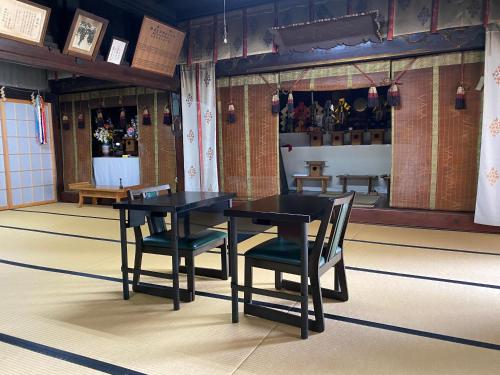 a dining room with a black table and two chairs at Shukubo Kanbayashi Katsukane in Tsuruoka