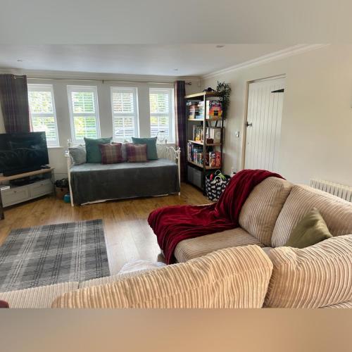 a living room with a couch and a tv at Peak District Period Property near Chatsworth House in Bakewell
