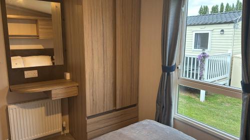 a bedroom with a window and a bed and a window at 3 bedroom Caravan Manor Park Free WiFi , Linen not included , Pets stay free in Hunstanton