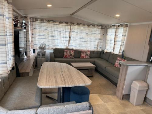 a living room with a couch and a table at 3 bedroom Caravan Manor Park Free WiFi , Linen not included , Pets stay free in Hunstanton