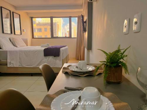 a living room with a bed and a table with a table sidx sidx at Lindo flat no Manaíra Apart Hotel in João Pessoa