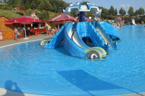a blue water slide in a water park at Otthonos lakás in Kerepes