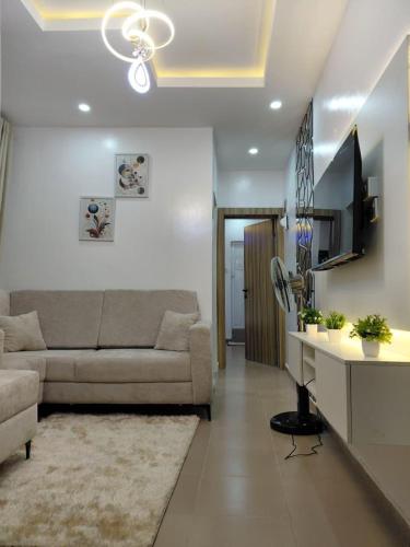 a living room with a couch and a tv and a table at Leap Phoenix Apartments in Lagos
