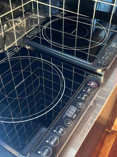 two remote controls sitting on top of an oven at Vacation rental PIGGY's Nichinan in Nichinan
