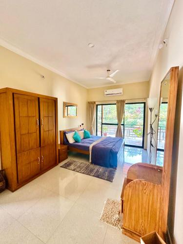 a bedroom with a bed and a large window at The Home Resort - Coorg in Kakkabe