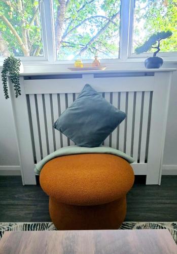 a pillow sitting on a chair in front of a window at Corby Stay 2BR Work Trips & Family Friendly in Corby
