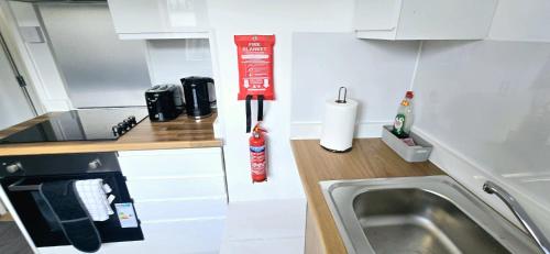 eine kleine Küche mit Spüle und Herd in der Unterkunft Corby Stay 2BR Work Trips & Family Friendly in Corby