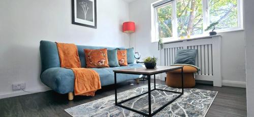 ein Wohnzimmer mit einem blauen Sofa und einem Tisch in der Unterkunft Corby Stay 2BR Work Trips & Family Friendly in Corby