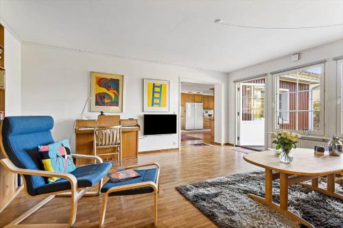 a living room with a blue chair and a table at TV1360-Bindslev-Munkebakken-5 in Bindslev