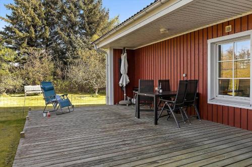 a deck with chairs and a table on a house at TV1360-Bindslev-Munkebakken-5 in Bindslev