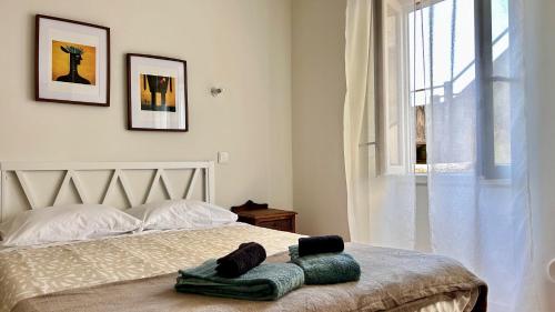 a bedroom with a bed with two towels on it at Terracota 2 Quartos Parque Cidade Pet Friendly in Aveiro