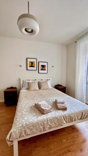 Un dormitorio con una cama grande con dos toallas encima. en Terracota 2 Quartos Parque Cidade Pet Friendly, en Aveiro