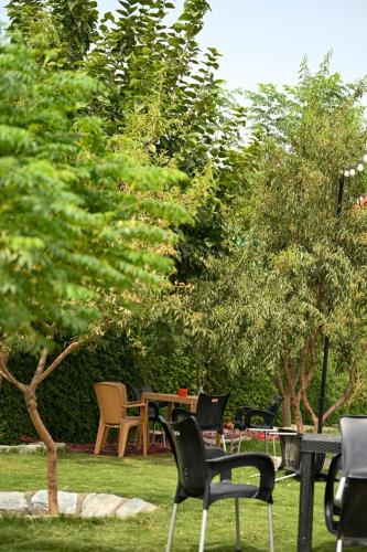 a group of chairs and a table in a garden at اكوخ في مزرعة بساتين اللوز in Quai