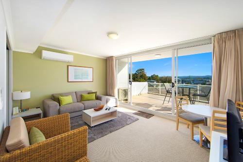 a living room with a couch and a table at Ettalong Beach Luxury Apartments in Ettalong Beach