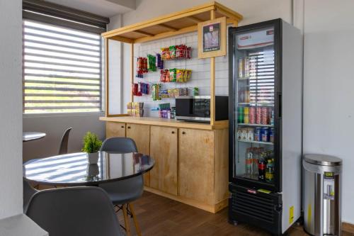 a room with a table and a refrigerator at Estancias VIVE MX el marqués in Hércules