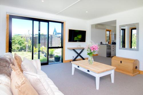 a living room with a white couch and a table at Te Awa Lodge Riverside retreat in Wanaka