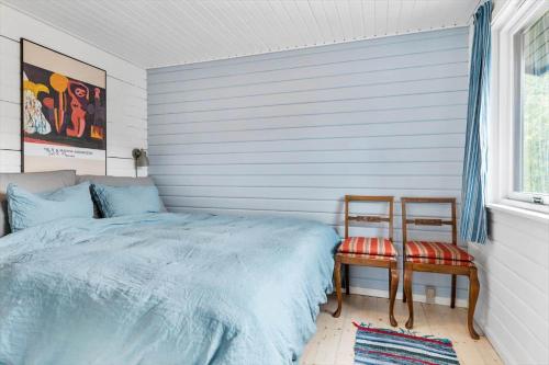 um quarto com uma cama azul e 2 cadeiras em TV1554-Albaek-Jupitervej-4 em Ålbæk