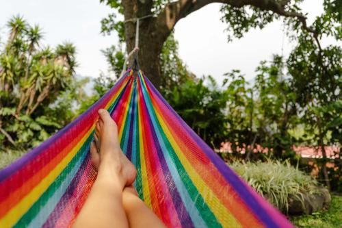 a person is holding a colorful hammock at Hotel Toliman in San Lucas Tolimán