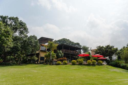 a building with red umbrellas in a yard at Hotel Toliman in San Lucas Tolimán