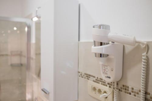 a white soap dispenser on the wall of a bathroom at ValDeSara in Malinska