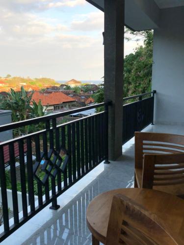 a balcony with a table and chairs and a view at Naomi Homestay in Padangbai