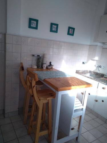 a kitchen with a table and two stools at VISTA AL MAR HOSPEDAJE Solo mujeres in Mar del Plata