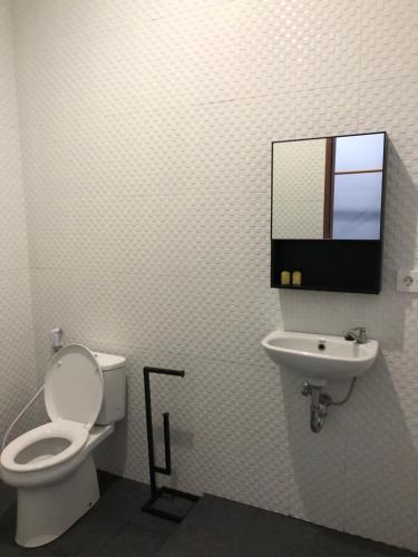 a bathroom with a toilet and a sink at Naomi Homestay in Padangbai
