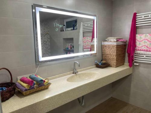 a bathroom with a sink and a mirror at Guest House KATO in Poti