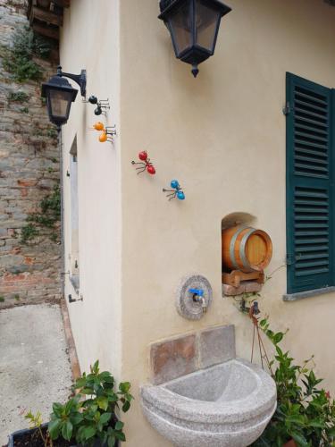 a stone bowl on the side of a building at Sant' Andrea Historic House in Calamandrana
