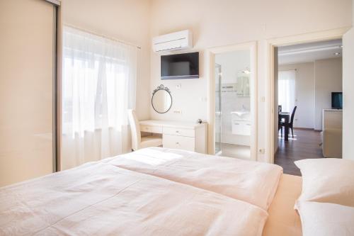 a white bedroom with a bed and a mirror at ValDeSara in Malinska