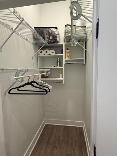 a walk in closet with white walls and white shelves at Modern 1-Bedroom Apartment in Downtown Baltimore in Baltimore
