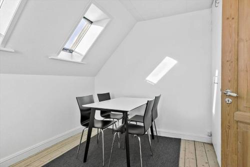 a table and chairs in a room with skylights at TV1476-Skagen-Kirkevej-2 in Skagen