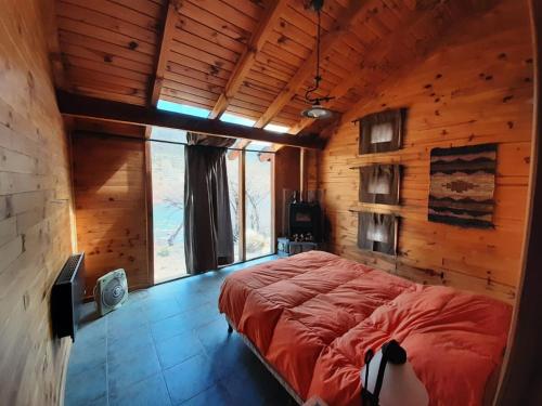 a bedroom with a large bed in a wooden room at Casa de campo en Pilolil Sobre el Río alumine in Pilolil