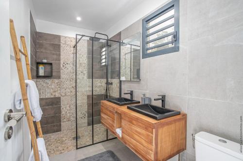 a bathroom with a sink and a glass shower at Villa de luxe vue exceptionnelle - MQDI92 10p in Le Diamant