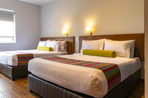 a hotel room with two beds and a window at Estancias VIVE MX el marqués in Hércules