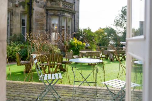 a patio with a table and chairs and a table at Taypark Garden View Apartment in Dundee