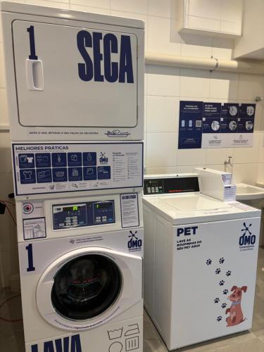 a washer and a washing machine in a room at Studio Mogi das Cruzes in Mogi das Cruzes