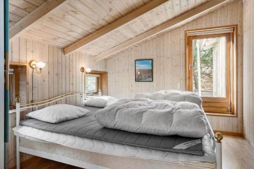 a bedroom with a large bed in a room at TV1415-Albaek-Zefyrvej-8 in Ålbæk