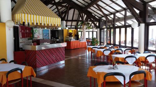 un restaurante con mesas y sillas y una cocina en Mobile Home Maslina, en Jezera