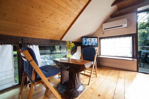 - une salle à manger avec une table, des chaises et des fenêtres dans l'établissement Guesthouse Slovin Unique - Rastoke, à Slunj