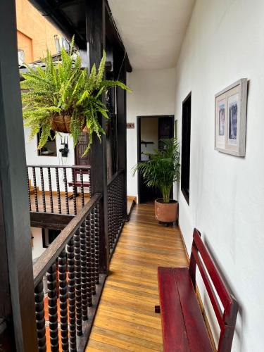 a hallway with a bench and potted plants at Casa Aranjuez in Bogotá