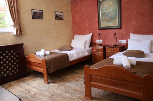 two beds in a room with red walls at Apartments Dragović Nikšić in Nikšić