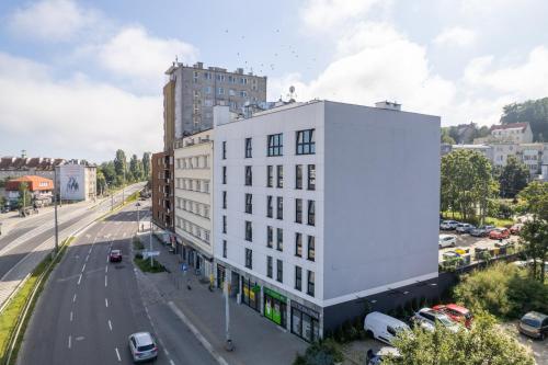 a white building on the side of a street at Apartamenty Przystanek Morska in Gdynia