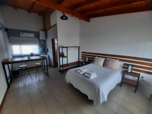 a bedroom with a bed and a desk and a table at Tambo Aparts in El Calafate