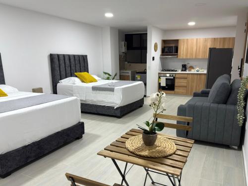 a bedroom with two beds and a living room at Nuevo apartamento en plaza principal de Guatape in Guatapé