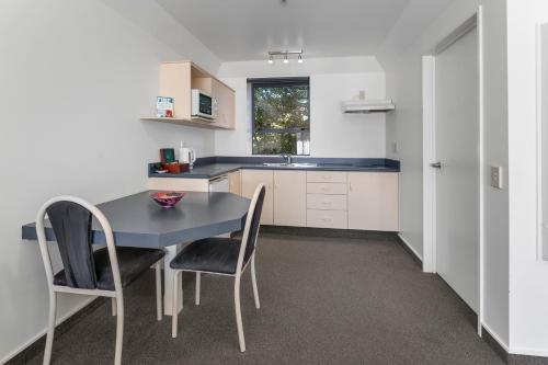 a kitchen with a table and chairs and a sink at Avalon Manor Motel in Motueka