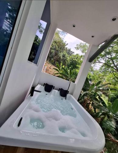 a white bath tub in a room with windows at Luxury Suite del Faro, Romance en la represa in Prado