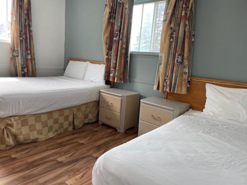 a bedroom with two beds and a window at Motel Lustre D'or in Quebec City